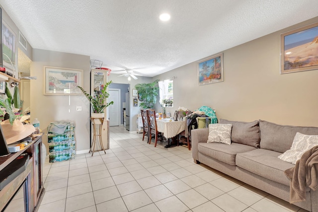 tiled living room with ceiling fan and a textured ceiling