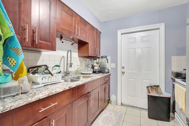 kitchen with sink, light stone countertops, and backsplash