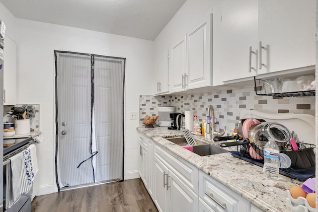 kitchen featuring decorative backsplash, sink, stainless steel electric range, white cabinetry, and dark hardwood / wood-style flooring