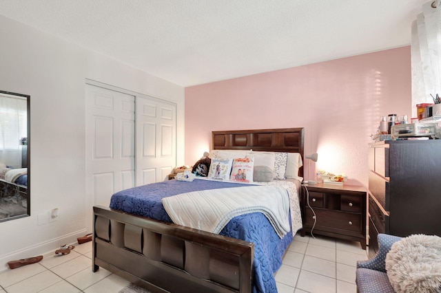 tiled bedroom with a closet and a textured ceiling