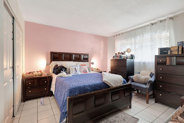 tiled bedroom featuring a textured ceiling and a closet