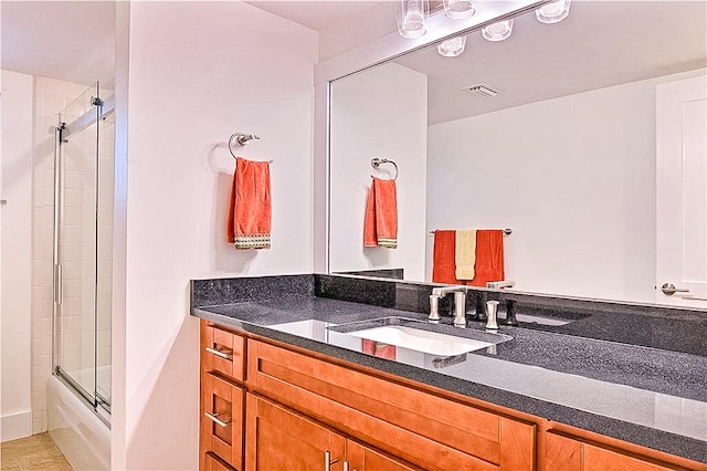 bathroom featuring vanity and combined bath / shower with glass door