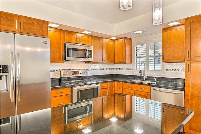 kitchen featuring backsplash, appliances with stainless steel finishes, and sink