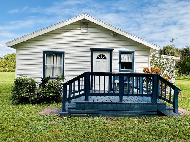 view of front of house with a storage shed and a front lawn