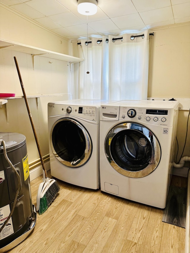 laundry room featuring water heater, laundry area, separate washer and dryer, and light wood-type flooring