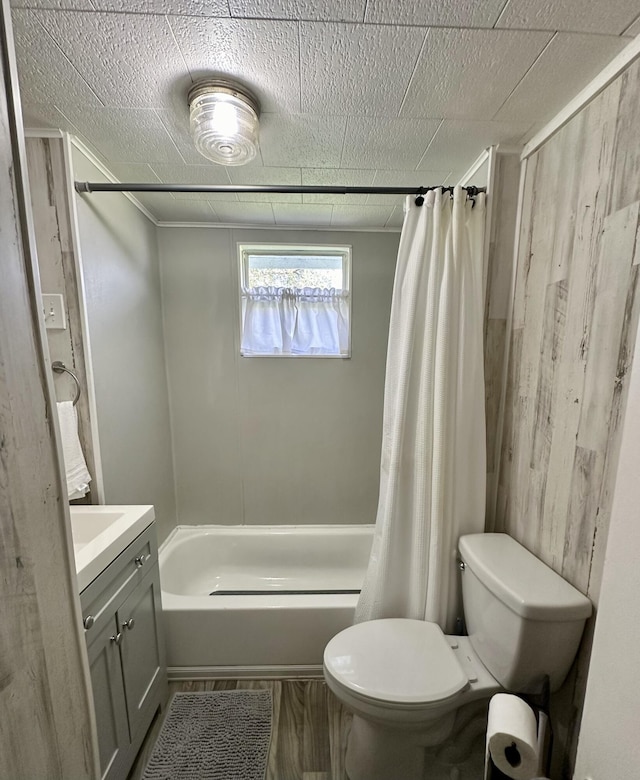 bathroom with shower / bath combo, vanity, toilet, and wooden walls