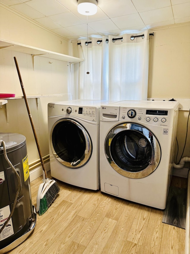 laundry area featuring washer and dryer, light wood finished floors, and water heater