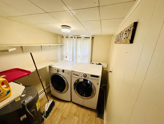 laundry area with washer and clothes dryer and light wood-style flooring