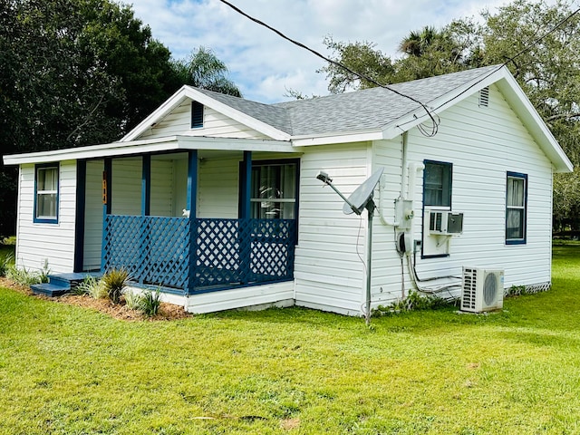 rear view of property featuring a yard, cooling unit, and ac unit