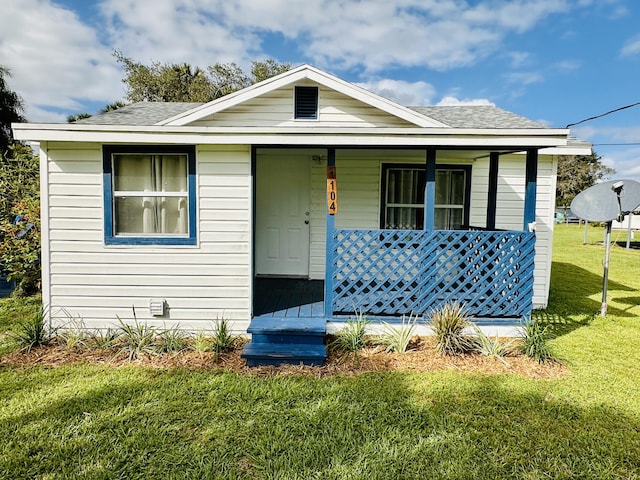 bungalow-style house featuring a porch, a front yard, and a shingled roof