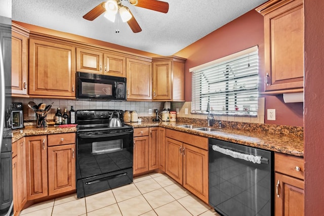 kitchen featuring sink, dark stone counters, a textured ceiling, decorative backsplash, and black appliances