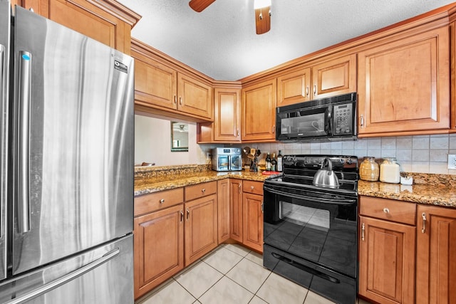 kitchen with black appliances, ceiling fan, light stone countertops, and a textured ceiling