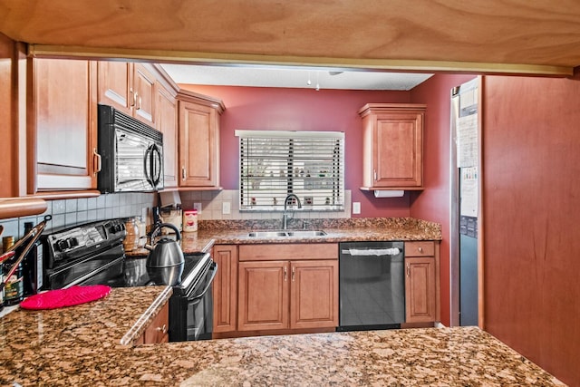 kitchen featuring black appliances, backsplash, stone countertops, and sink