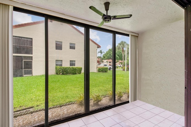 doorway to outside with light tile patterned floors, a textured ceiling, plenty of natural light, and ceiling fan