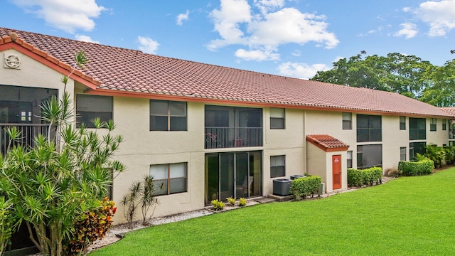 back of property with a yard and central air condition unit