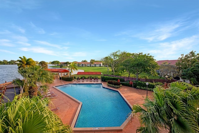 view of swimming pool featuring a water view and a patio