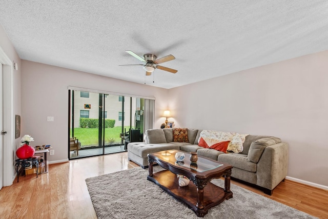 living room with hardwood / wood-style floors, a textured ceiling, and ceiling fan