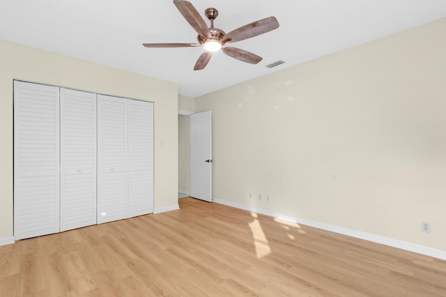 unfurnished bedroom with ceiling fan, light hardwood / wood-style floors, and a closet