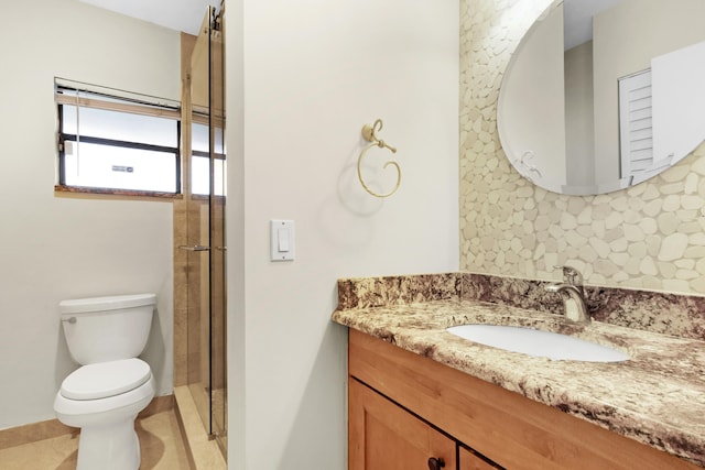 bathroom with a shower with shower door, backsplash, vanity, toilet, and tile patterned floors