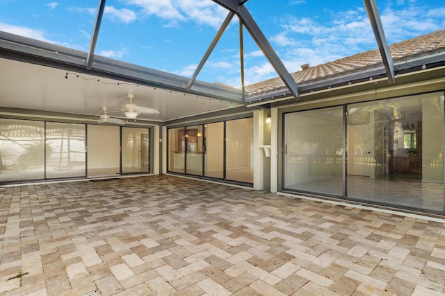 exterior space featuring ceiling fan and glass enclosure