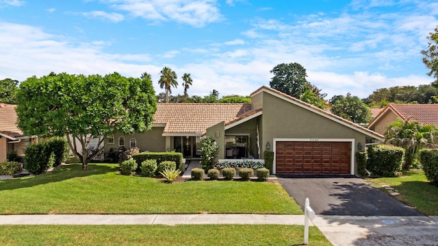 ranch-style home featuring a garage and a front lawn