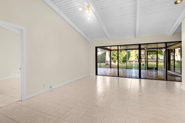 tiled empty room with beam ceiling, track lighting, and high vaulted ceiling