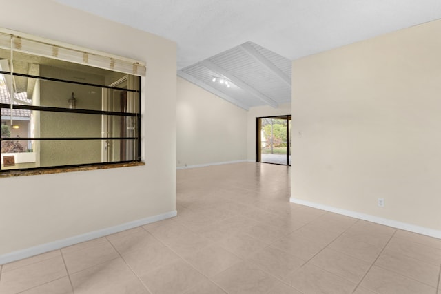 tiled empty room with lofted ceiling with beams