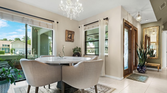 tiled dining room with a chandelier