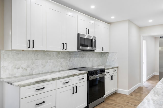 kitchen featuring stainless steel appliances, light stone countertops, light hardwood / wood-style flooring, and white cabinets