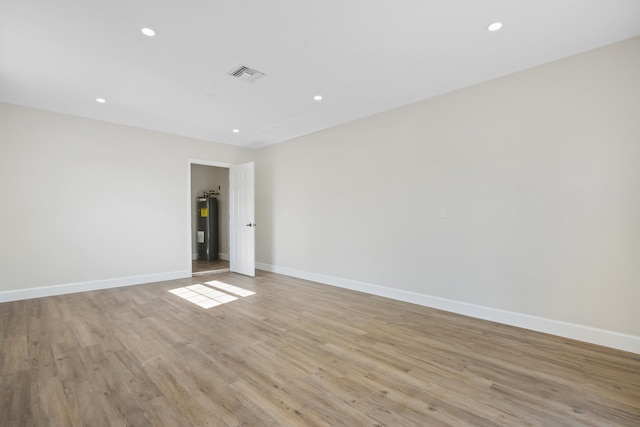 empty room featuring light hardwood / wood-style flooring and electric water heater