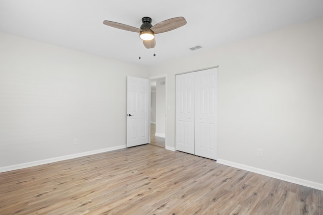 unfurnished bedroom with light hardwood / wood-style floors, a closet, and ceiling fan