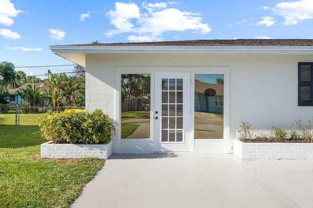 doorway to property with a yard and a patio