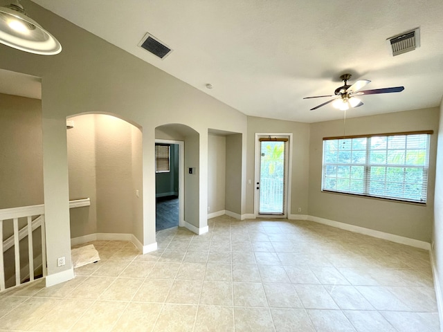 tiled spare room featuring ceiling fan and vaulted ceiling