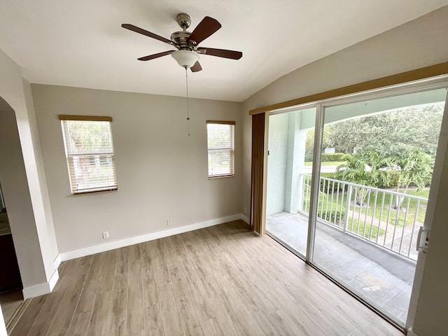 spare room featuring light hardwood / wood-style flooring, vaulted ceiling, and ceiling fan