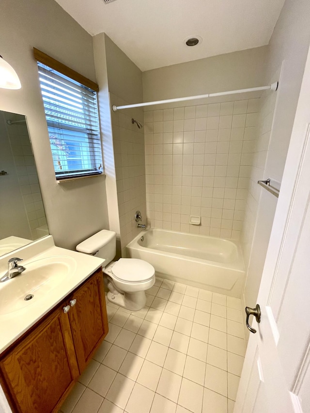 full bathroom featuring vanity, tiled shower / bath, toilet, and tile patterned flooring