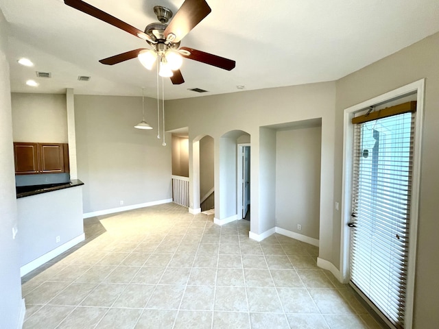 unfurnished living room featuring ceiling fan and light tile patterned flooring