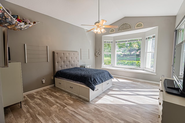 bedroom featuring lofted ceiling, refrigerator, ceiling fan, and light wood-type flooring