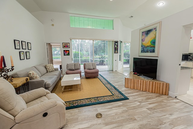 living room featuring light hardwood / wood-style floors, high vaulted ceiling, and a wealth of natural light