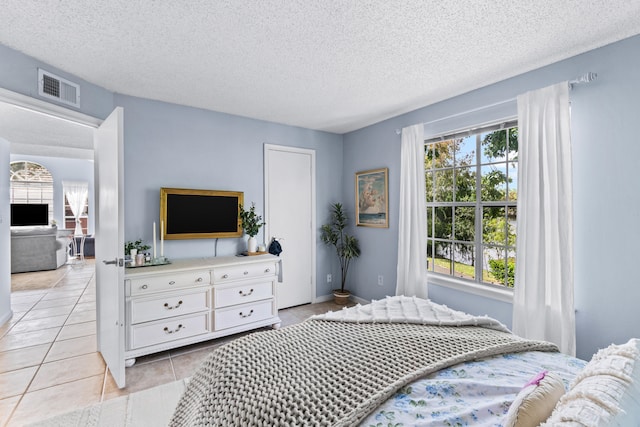 tiled bedroom with a textured ceiling