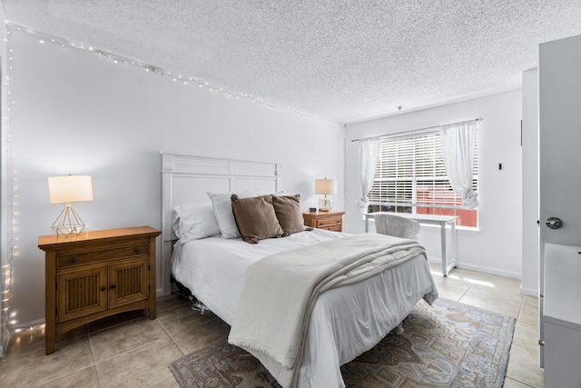 bedroom with a textured ceiling and light tile patterned floors