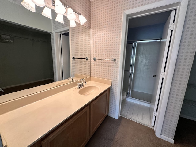 bathroom with a shower with door, vanity, and toilet