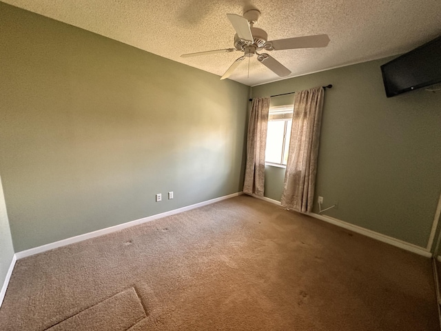 carpeted empty room with ceiling fan and a textured ceiling