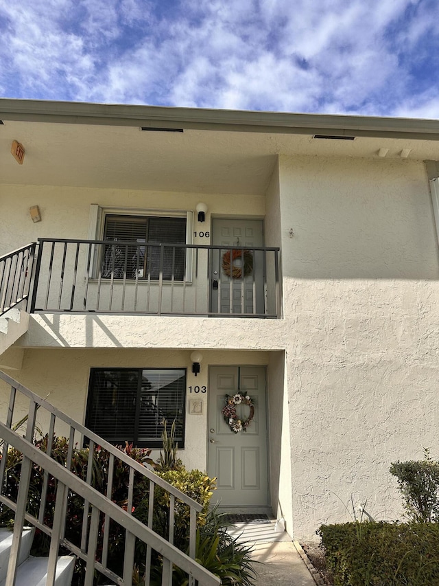 view of exterior entry featuring a balcony