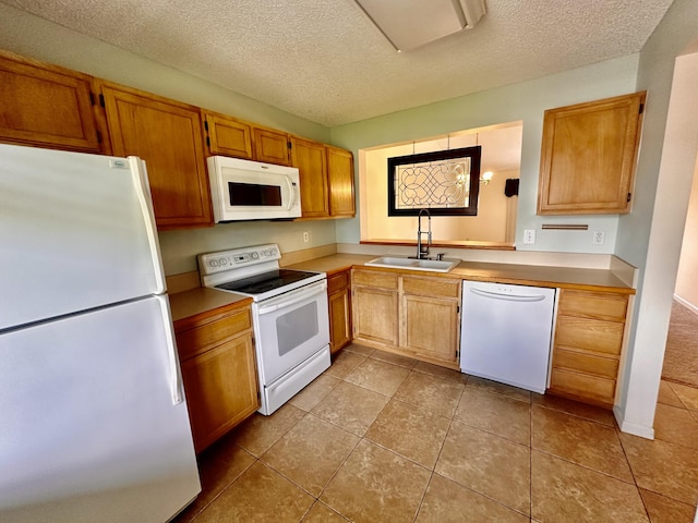 kitchen with white appliances, light tile patterned flooring, a textured ceiling, and sink