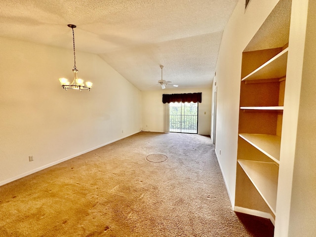 spare room featuring a textured ceiling, vaulted ceiling, carpet floors, and ceiling fan with notable chandelier