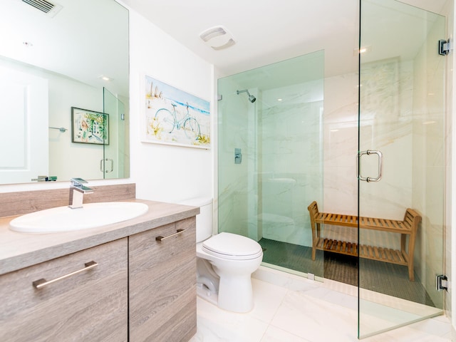 bathroom featuring toilet, vanity, and a shower with door