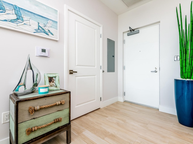 foyer entrance with electric panel and light hardwood / wood-style floors