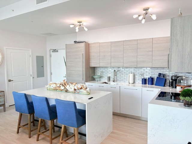 kitchen featuring tasteful backsplash, a kitchen bar, light hardwood / wood-style floors, and a center island