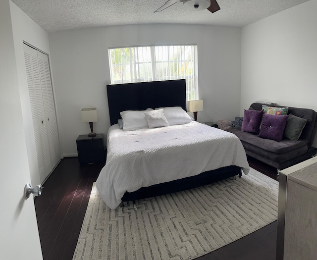 bedroom with dark hardwood / wood-style flooring, a closet, a textured ceiling, and ceiling fan