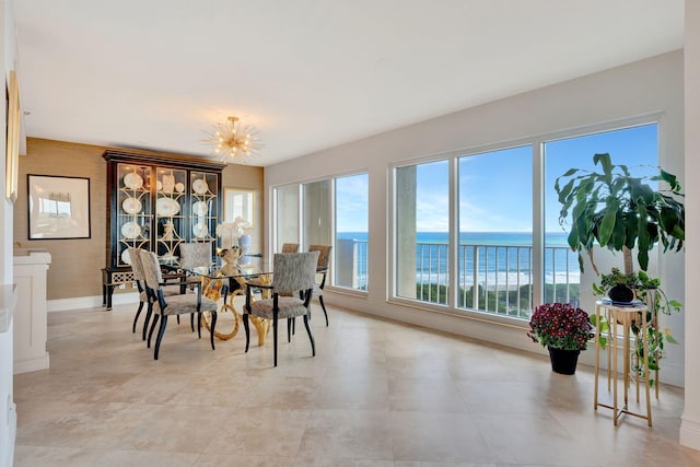 dining space with a water view and an inviting chandelier